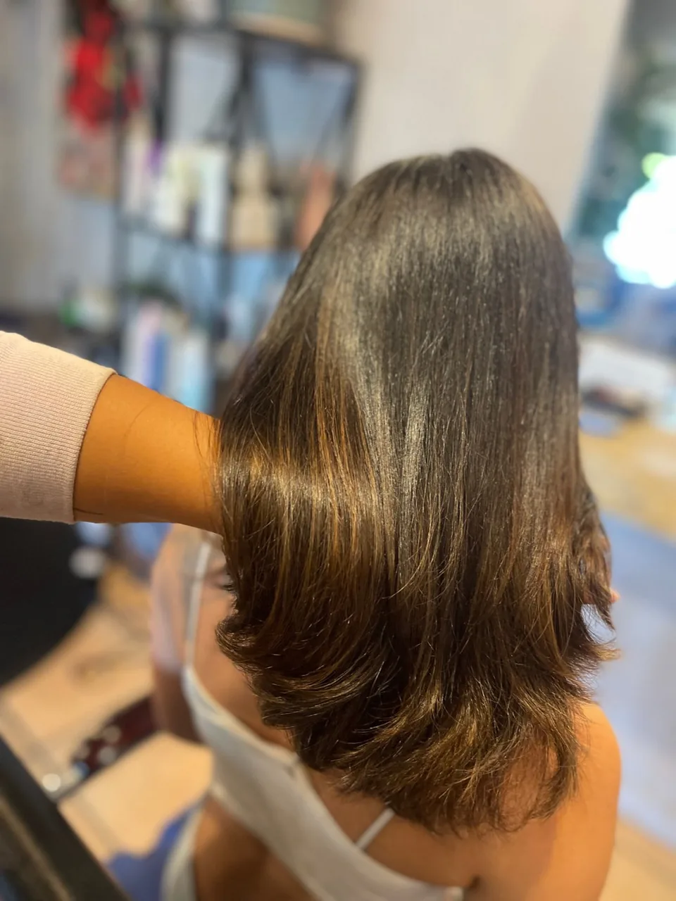 A smooth glass-finish blowout on brown hair.