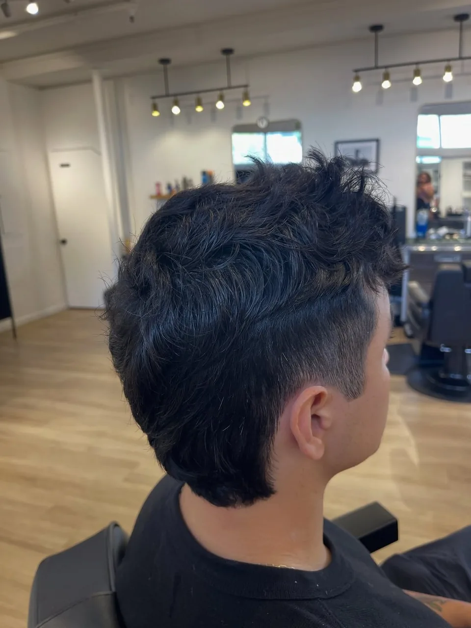 A men&rsquo;s modern mullet with tapered sides and volume through the top.