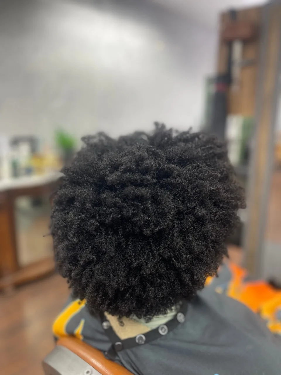 A natural afro shaped into an even, rounded outline.