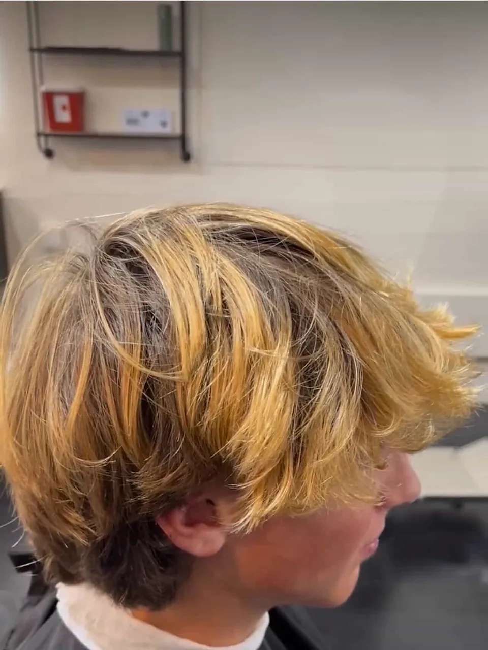 A shaggy blonde mullet, heavily textured through the top with a longer nape.
